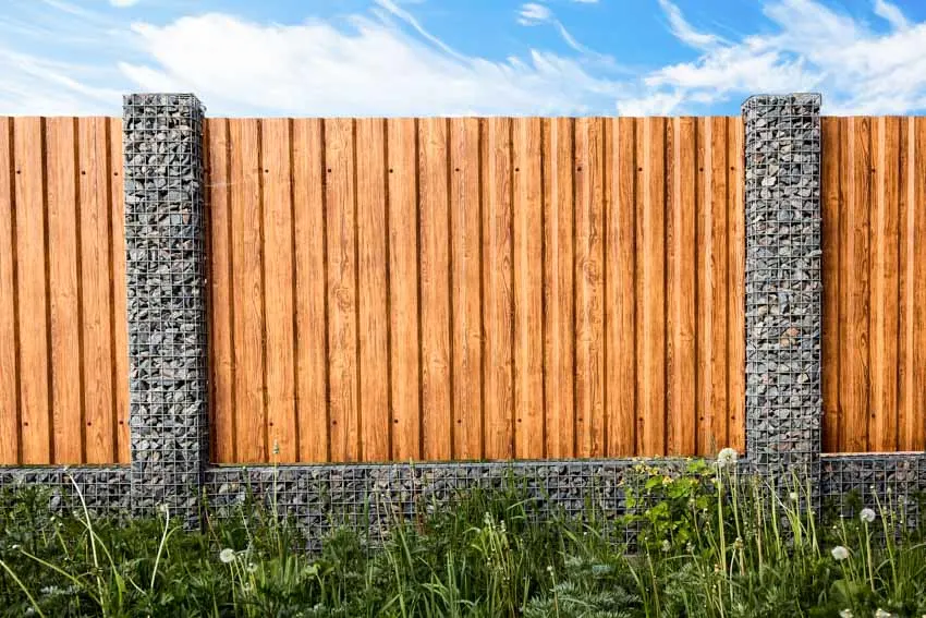 Wood overlapping fence with stone pillars