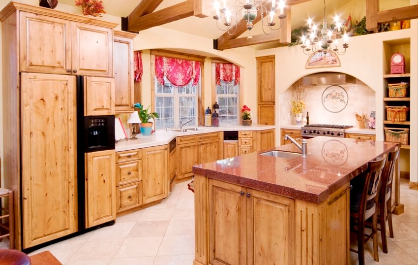 Kitchen with wood beams on ceiling, red granite counter and red drapery on window