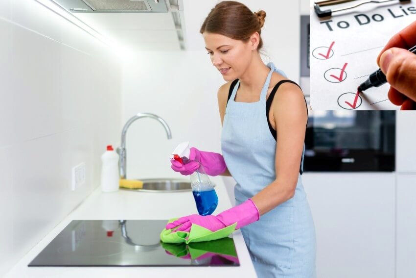 A young adult woman in apron and rubber gloves, cleaning induction stove in modern kitchen using wipe cloth and detergent spray