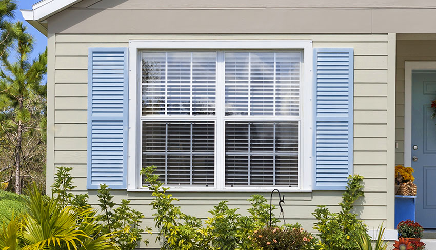 House with French window with shutters and blinds clapboard siding