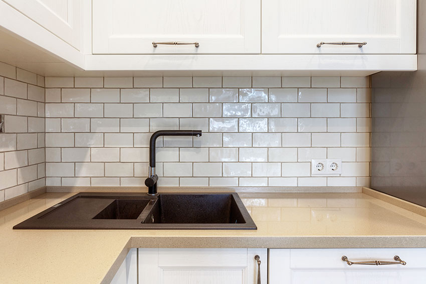 Kitchen counter with black sink white tile backsplash common backsplash mistakes
