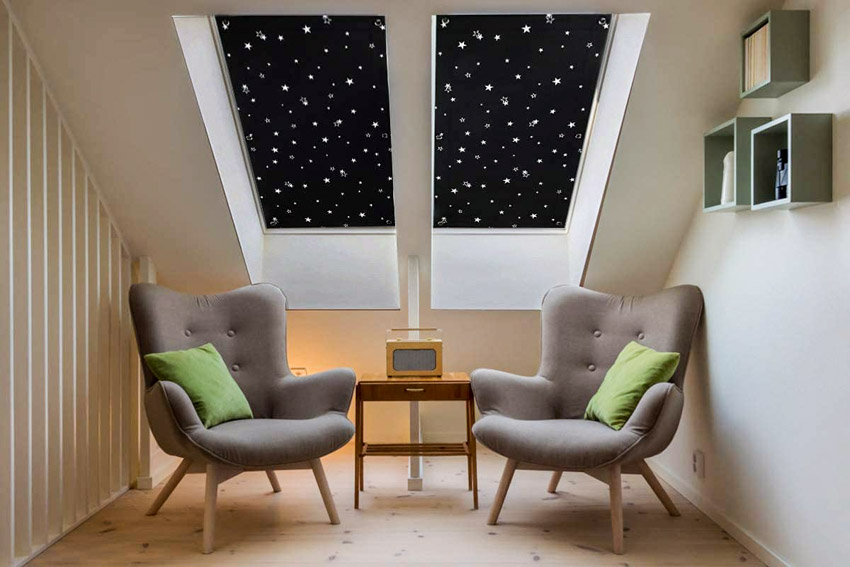 Attic living room with accent chairs, skylight windows, wood floors, and portable blackout curtains