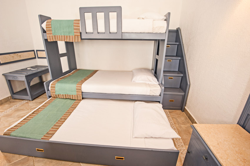 Bedroom with bunk bed trundle, mattress, stairs, pillows, and wood floor