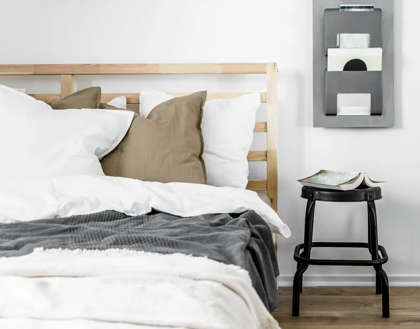 Bedroom with comforter, pillows, headboard, and stool as creative nightstand alternative