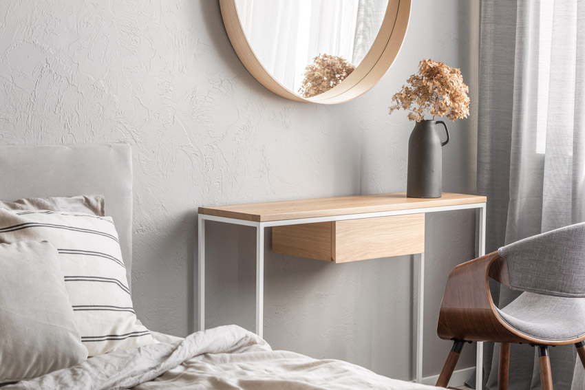 Bedroom with mirror, chair, and console table as creative nightstand alternative