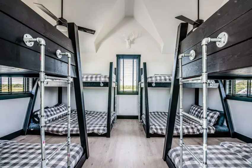 Bedroom with several adult bunks, windows, and mattresses