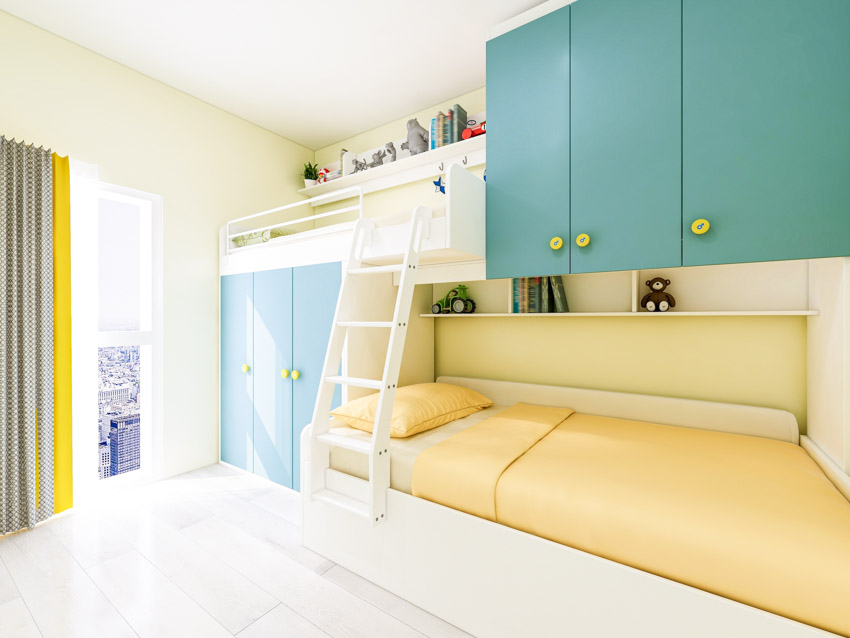 Bedroom with yellow mattress, cabinets, ladder, and bunk