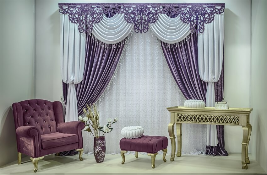 A classic style interior features velvet double sided curtains with openwork tulle and carved pelmet