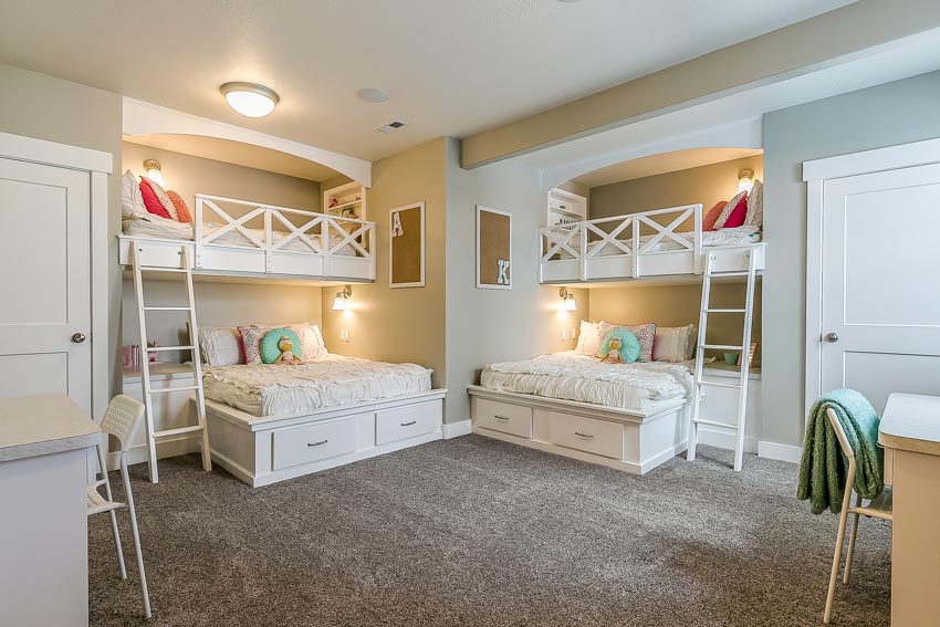 Children's bedroom with built-in bunk beds, carpet floor, ceiling lights, pillows, and doors