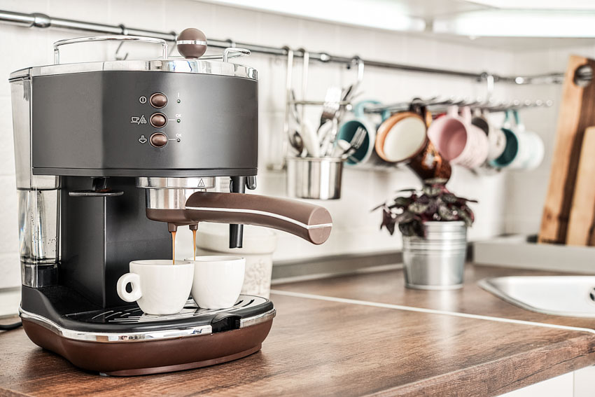 Coffee bar with coffee maker, wood countertop, indoor plant, and cups