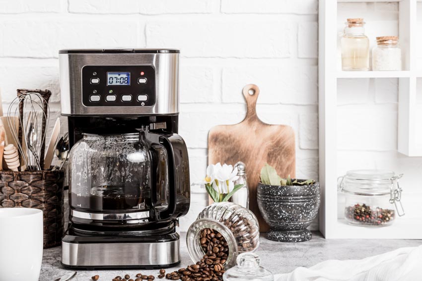 Coffee bar with modern coffee maker, cutting board, and container of coffee beans