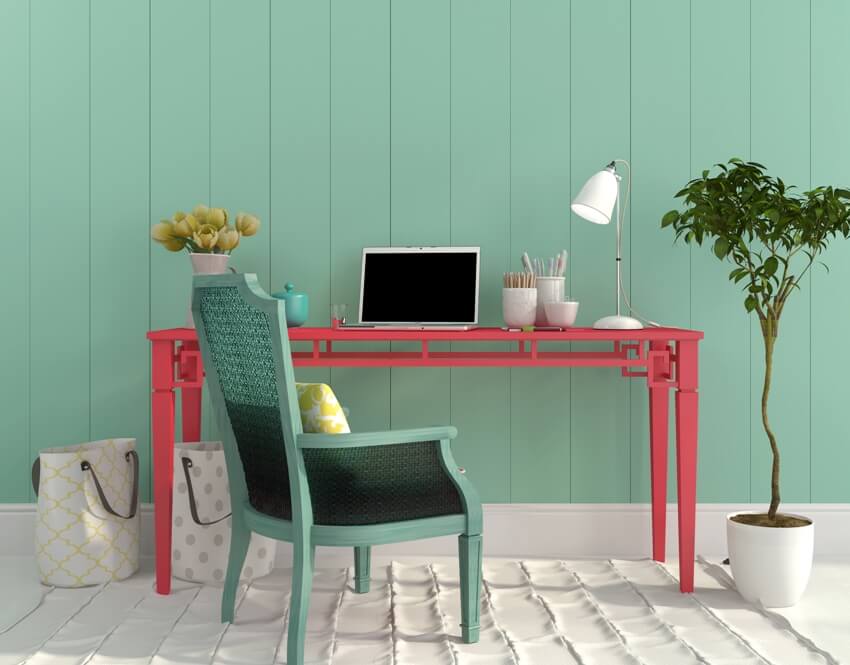A colorful home office interior with red desk and a turquoise chair