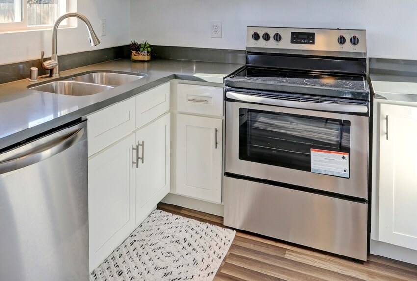 Compact kitchen with hardwood floors, slab countertop and conventional oven