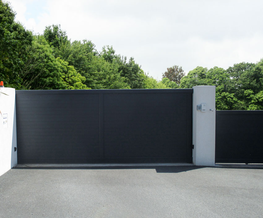 Concrete driveway with black sliding gate design