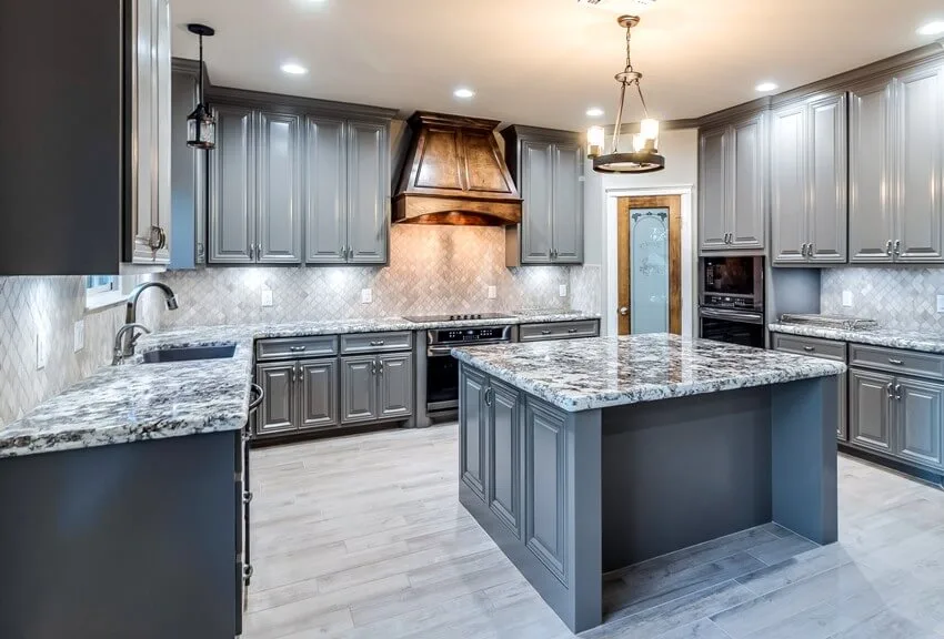 Kitchen with granite countertops, island and natural stone flooring