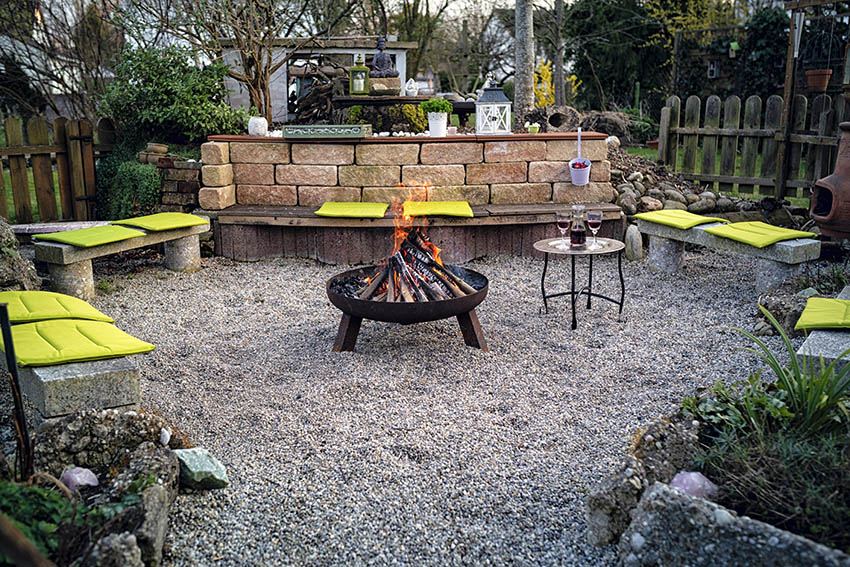 Crushed gravel patio with concrete benches fire pit