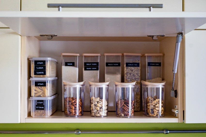 Deep pantry organization on shelf at kitchen cupboard with different dry foods that are categorized in containers