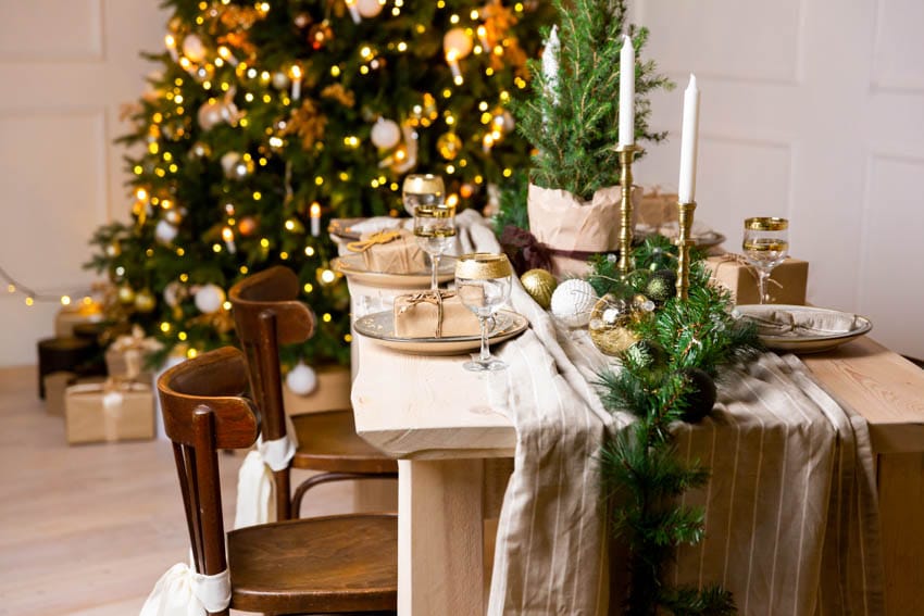 Room with festive decorations, table, plates, centerpieces and chairs