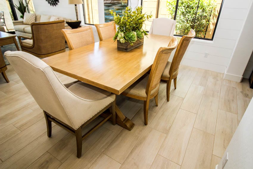Dining room with wood table, chairs, wooden flooring, windows, and centerpiece