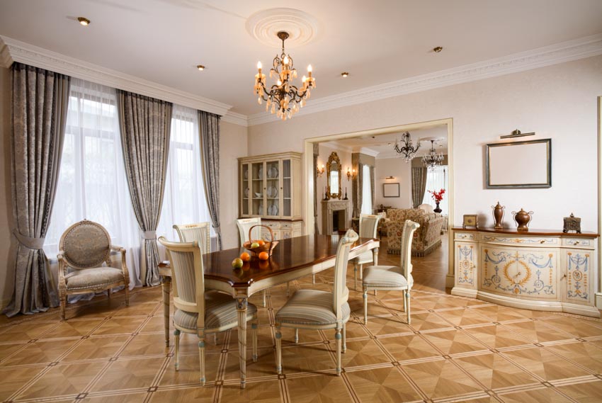 Elegant dining room with patterned floor, brocade curtain, table, chairs, and chandelier