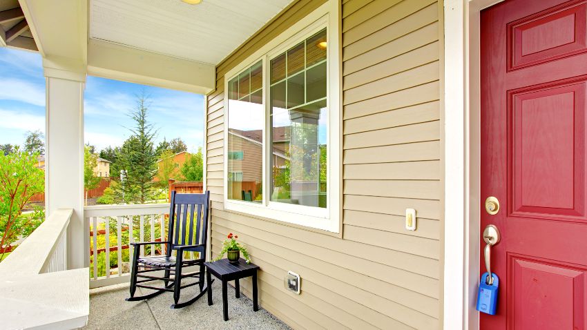 Porch with white framed windows, rocking chair and table