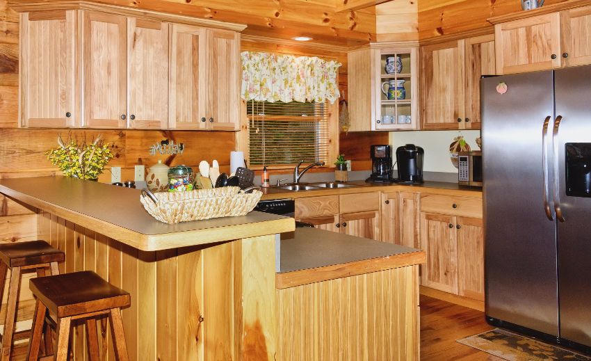 Full sized kitchen with hickory cabinets and bar area in cozy cabin