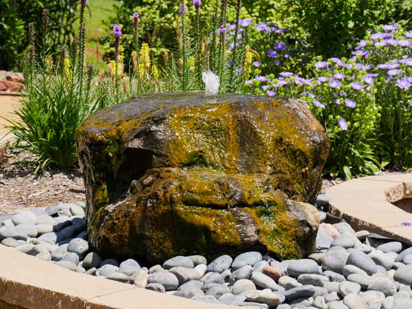 Garden with landscaping rocks, plants, and pondless fountain