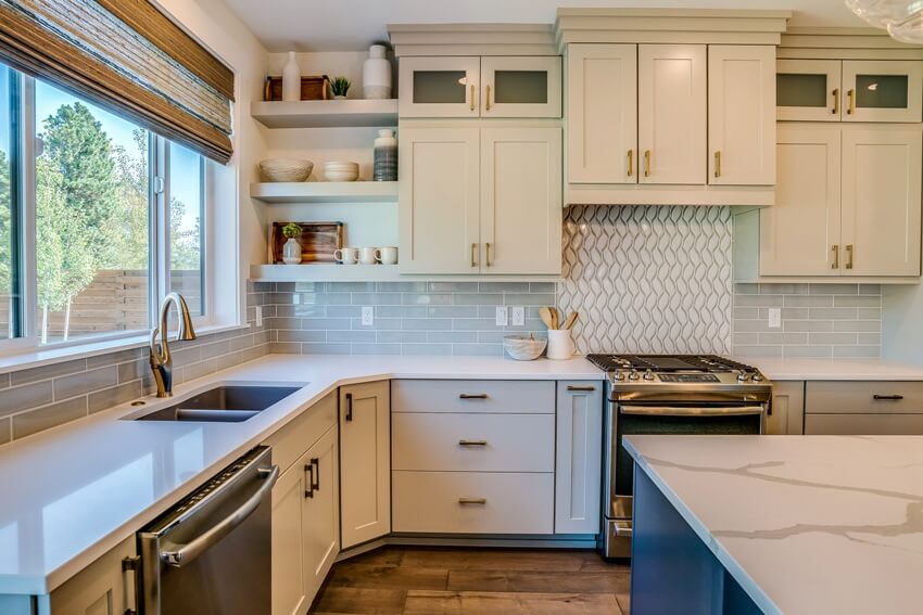 Kitchen with white cabinets and chevron design backsplash