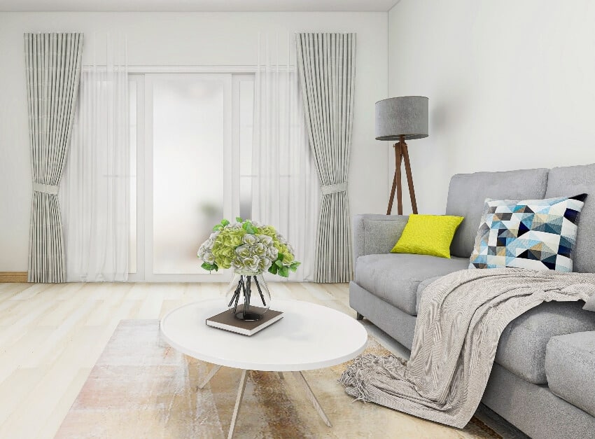 Grey and white tone cozy room with sofa, table, floor lamp and double tone curtains