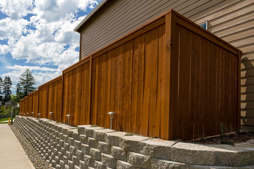 House exterior with foundation, red cedar wood fence, and siding