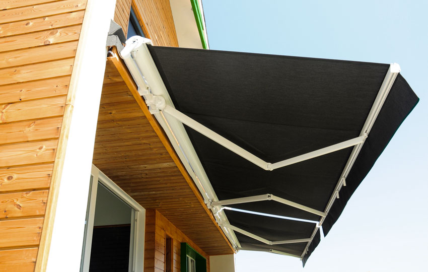 House exterior with wood siding, and retractable awning as patio umbrella alternative
