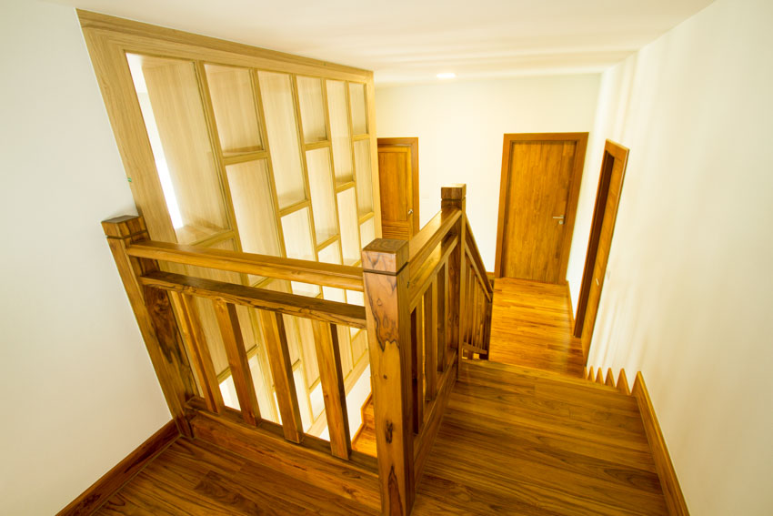 House staircase with teak wood, railing, and accent wall