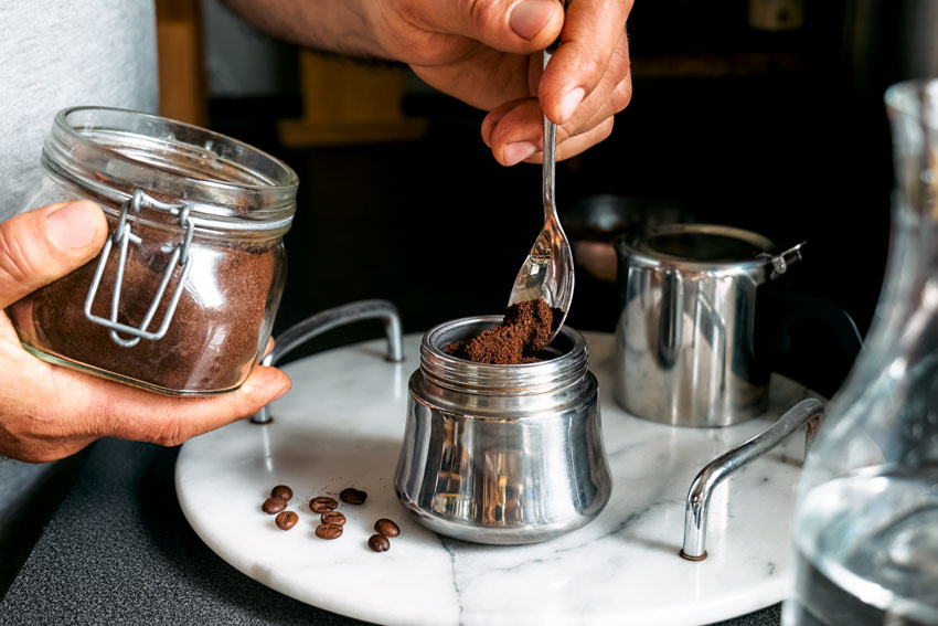 Individual placing spices for coffee inside container