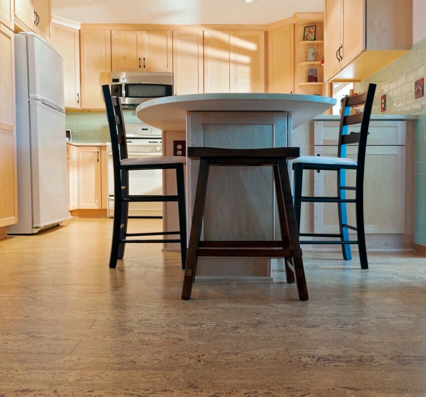 Kitchen interior with dining set, cork floors, maple cabinets and a fridge