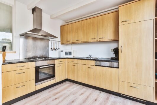 Kitchen Interior With Laminate Wood Floors Gas Range With Hood And Plywood Kitchen Cabinets Is 531x354 