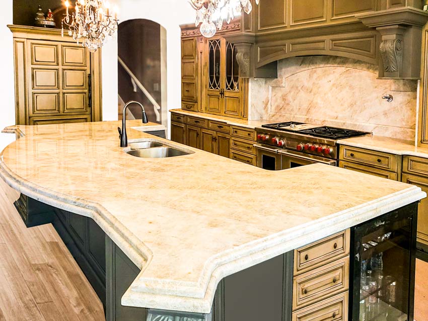 Kitchen with center island, countertop, sink, faucet, limestone backsplash, and wood flooring