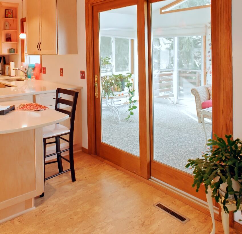 Kitchen with cork flooring and a view of entryway porch from sliding door