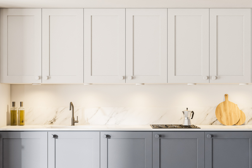 Kitchen with countertop, quartz backsplash, white and gray cabinets