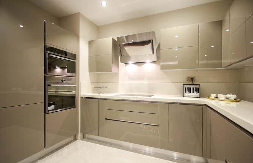 Kitchen with frameless cabinet doors, backsplash, oven, stove, and range hood