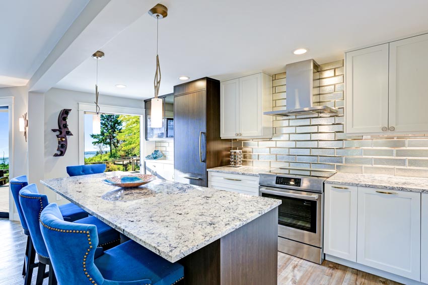 Kitchen with countertops, chairs, range hood, blue chairs and light wood flooring