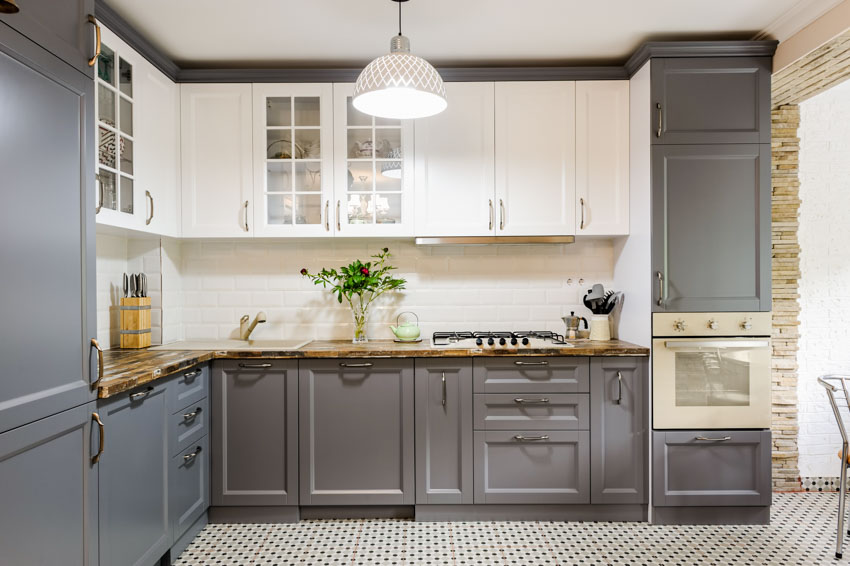 Kitchen with white and gray cabinets, patterned floors, countertop and backsplash