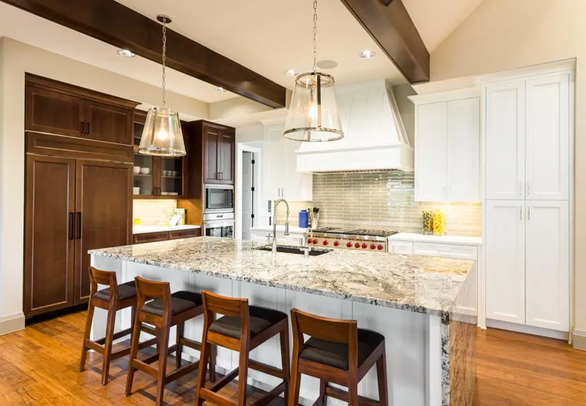 Kitchen with two tone cabinetry and granite waterfall counter