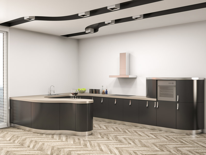 Kitchen with wood herringbone floors and dark gray cabinets