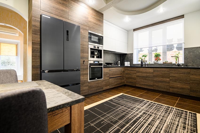 Kitchen with wood slab cabinet doors, refrigerator, tile floors, countertop, backsplash, and window