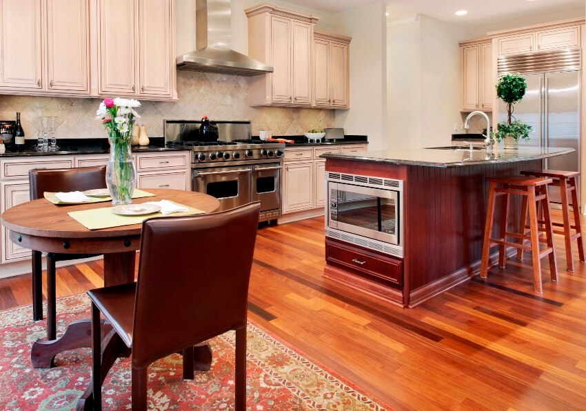 Kitchen with hardwood furniture, hardwood floors, island with cabinet types of ovens, large range with oven and a medallion rug
