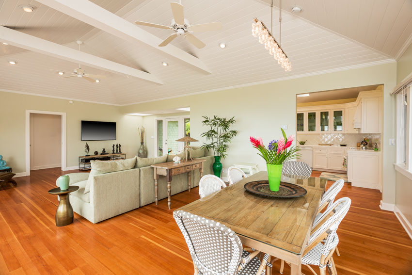 Open layout with view of dining and living areas and wood ceiling fan