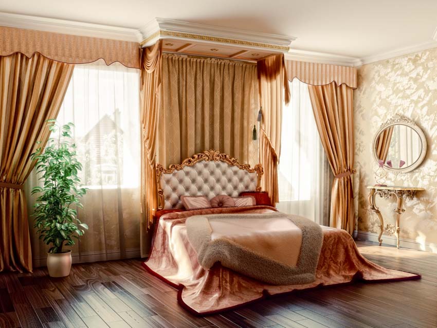 Luxurious bedroom with silk curtain, wood floor, bed, headboard, comforter, pillows, vanity table, mirror, and indoor table