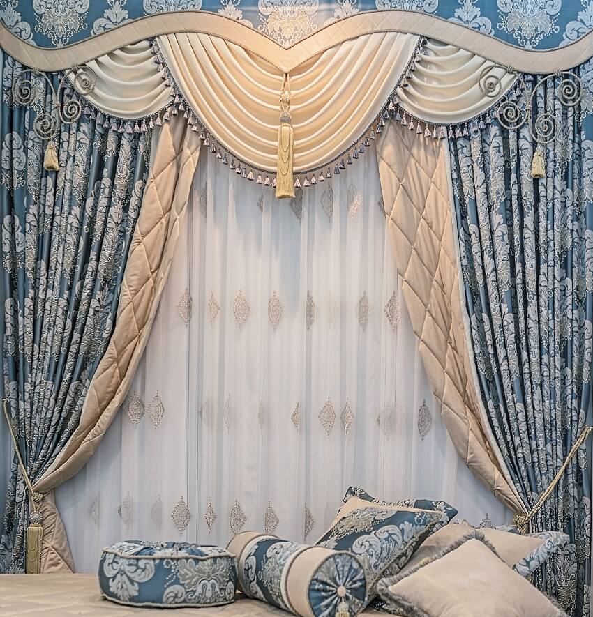 Luxury double sided curtain with floral ornaments, pelmet and pillows on the bed