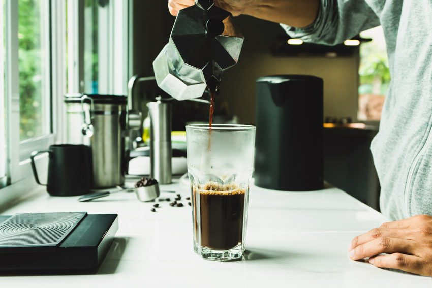 Man pouring coffee using cold brew maker for home coffee bars