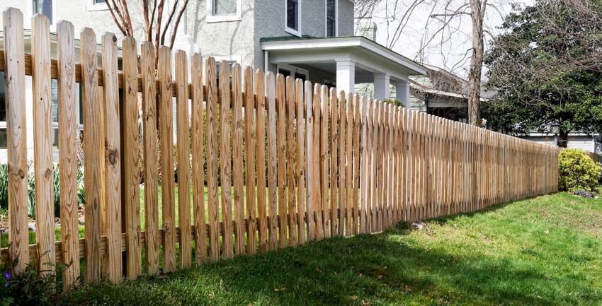 Unpainted picket fences with white house